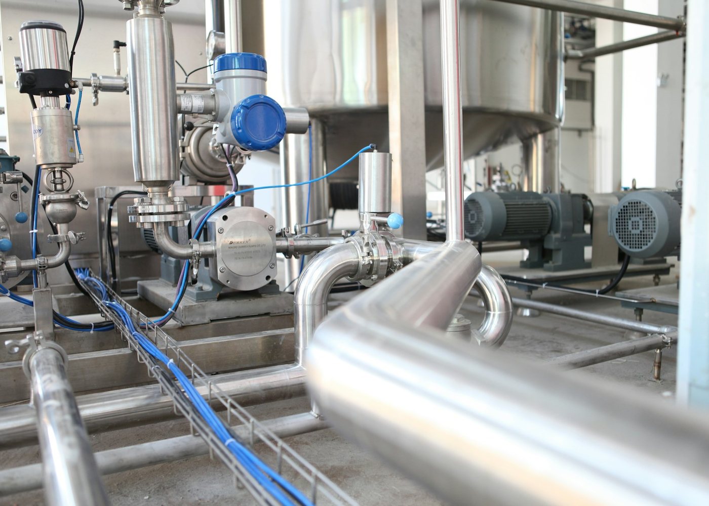 Stainless steel process piping and pumps in a plant room, mechanical and HVAC sourcing by HPM Materials
